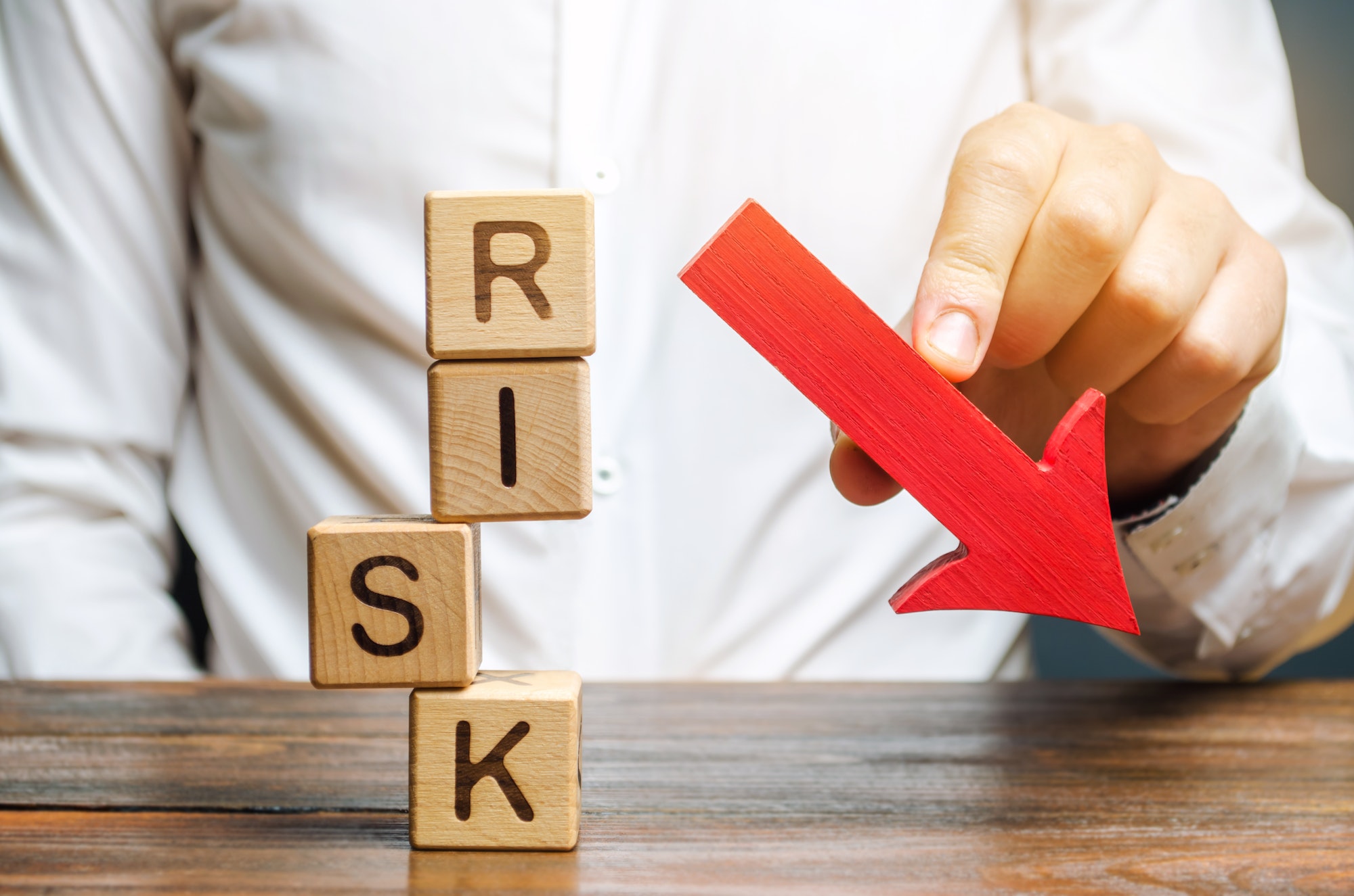 Wooden blocks with the word Risk and a down arrow